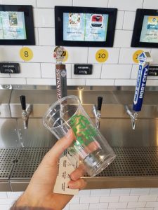 Empty beer cup in front of beer taps