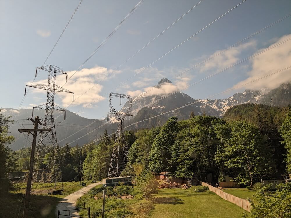 Power lines through forests with Cascade mountains in the background